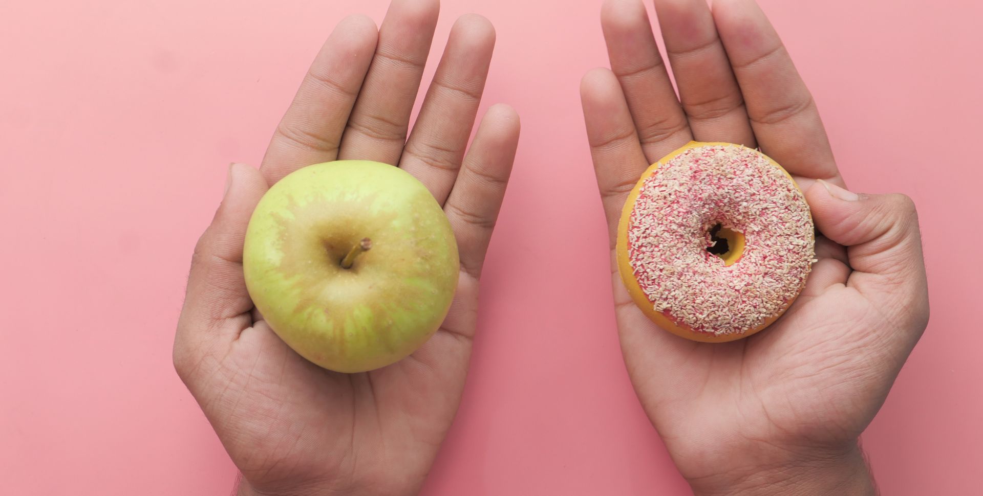 twee handen, eentje met een appel en eentje met een doughnut. keuzes maken
