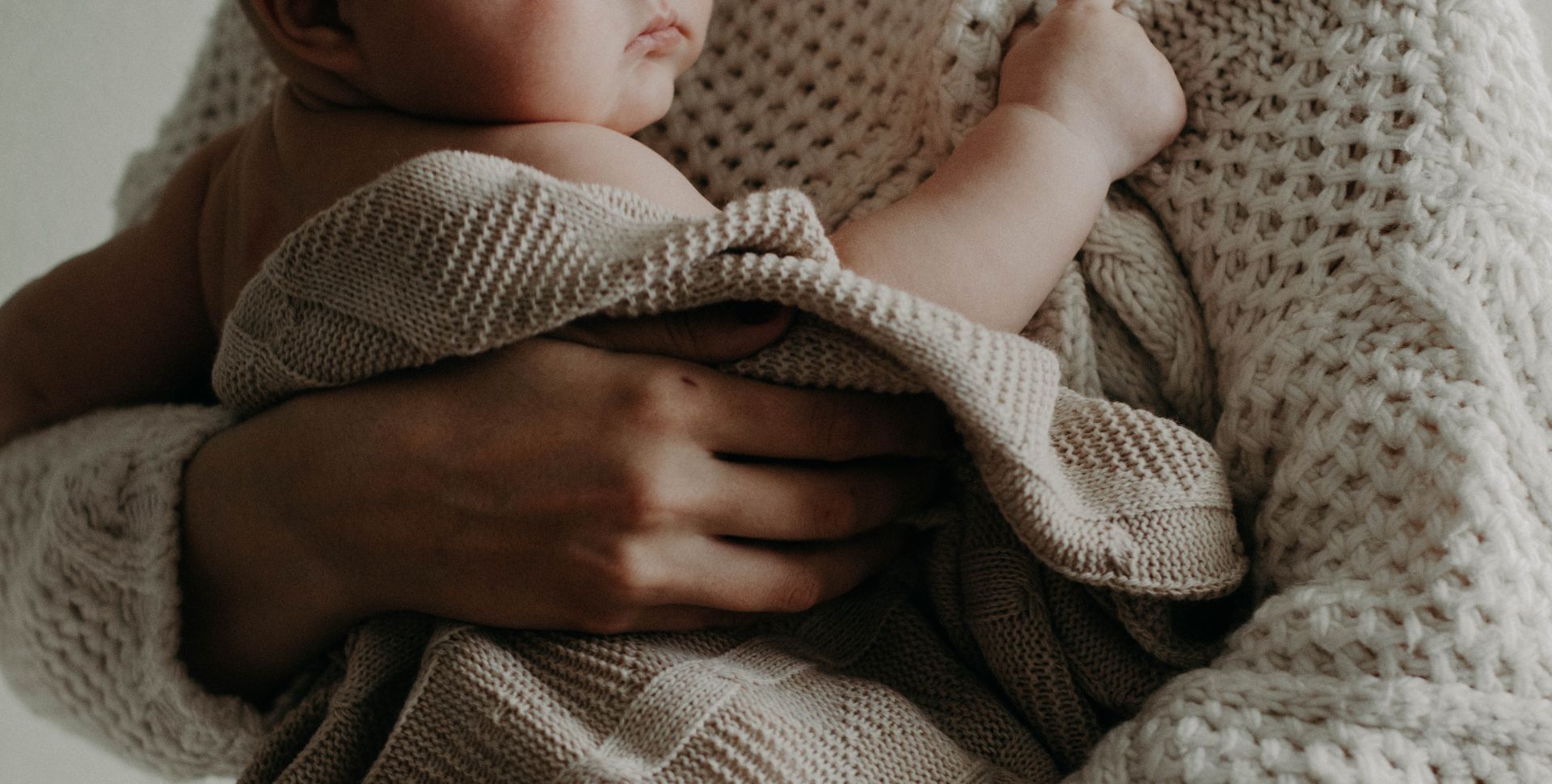 Foto moeder met baby in doeken gewikkeld